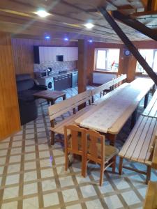 a kitchen with wooden tables and benches in a room at соколів камінь in Novoselitsa
