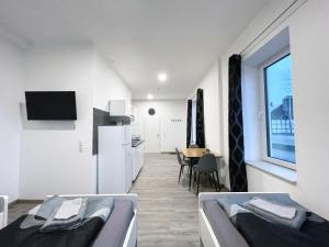 une chambre avec deux lits et une cuisine avec une table dans l'établissement Hochwertige Studios für Monteure I home2share, à Stemshorn