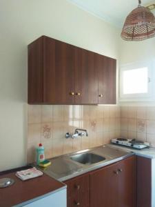 a kitchen with wooden cabinets and a sink at Kostas Studios II in Vasiliki