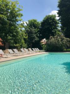 basen z leżakami i błękitną wodą w obiekcie Hotel Milano Pool & Garden w mieście Salice Terme