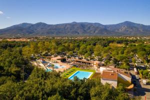 an aerial view of a resort with a pool and mountains at Camping maeva Club Argelès Vacances in Argelès-sur-Mer