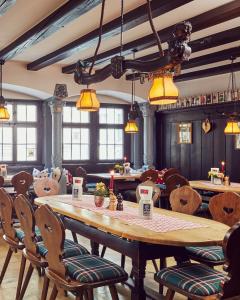 Hotel Engel - Lindauer Bier und Weinstube في لينداو: مطعم به طاولة وكراسي خشبية كبيرة