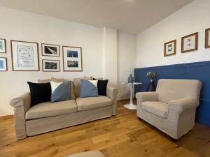 uma sala de estar com um sofá e duas cadeiras em Captain’s cabin em Koper