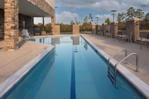 uma grande piscina com água azul em Hyatt Place Charlotte University em Charlotte