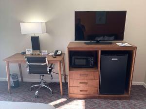 a room with a desk with a television and a chair at Urban Boutique Hotel; BW Signature Collection in Greenville