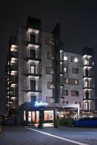 un gran edificio con luces encendidas por la noche en Radisson Hotel Nola Naples, en Nola