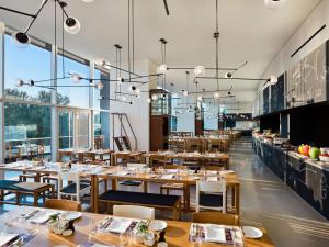 a restaurant with tables and chairs and large windows at East Beijing in Beijing