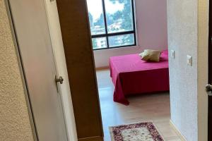 una camera con letto rosa e finestra di Appartamento vista lago con piscina a Lugano