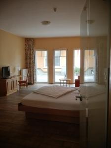 a hotel room with a bed and a glass door at Gästehaus Reßler in Harxheim