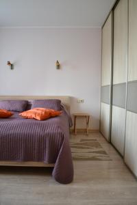 een slaapkamer met een paars bed en een dressoir bij Šaulys1 in Druskininkai