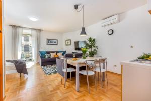 a kitchen and living room with a table and chairs at Main Street Apartments 2 in Rijeka