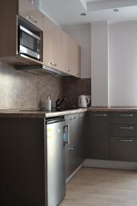 a kitchen with a stainless steel refrigerator and a microwave at Šaulys1 in Druskininkai