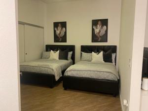 a bedroom with two beds and two pictures on the wall at Exceptional Loft FREE Parking and WIFI in Los Angeles