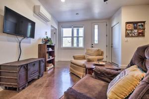 a living room with a couch and a flat screen tv at Quaint Kanab Casita - 3 Mi to the Heart of Town! in Kanab
