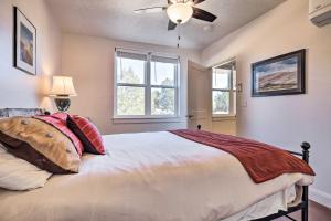 1 dormitorio con 1 cama, ventilador de techo y ventanas en Quaint Kanab Casita - 3 Mi to the Heart of Town!, en Kanab