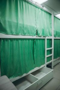 a green curtain is hanging in a room at Hostel CUBA in Minsk