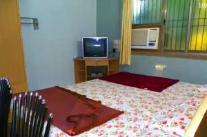 a bedroom with a bed and a tv on a table at Nanndi Holiday stay in Kīhīm