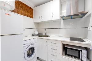 a kitchen with white cabinets and a washer and dryer at Studio Playa del Cura in Torrevieja +14 photos