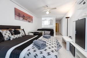 a bedroom with a black and white bed and a television at Studio Playa del Cura in Torrevieja