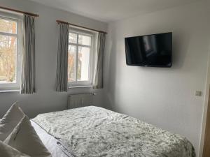 Schlafzimmer mit einem Bett und einem Flachbild-TV an der Wand in der Unterkunft Traumferienwohnung Ostseebad Baabe - Rügen in Baabe
