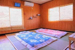 Duas camas num quarto com paredes e janelas de madeira em Machiyado AETE - Vacation STAY 22032v em Sanuki