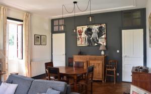 a living room with a table and an elephant picture on the wall at Appartement Erlandebaita Centre bourg 3 personnes in Urrugne