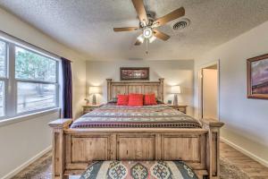 a bedroom with a wooden bed with a ceiling fan at Ruidoso House with Beautiful Indoor and Outdoor Space! in Ruidoso