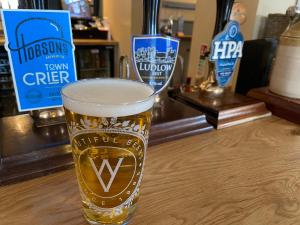a glass of beer sitting on a table at The Boyne Arms in Burwarton