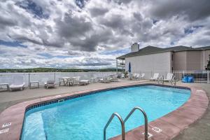 a swimming pool on a deck with chairs and tables at Lakefront Escape with Water Views and Pool Access in Lake Ozark