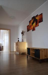 een woonkamer met een dressoir en schilderijen aan de muur bij Šaulys1 in Druskininkai