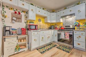 a kitchen with white cabinets and yellow walls at Stunning Gulfport Getaway about 1 Mi to the Beach in Gulfport