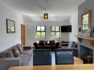 Tavnaghoney Cottages في كوشيندال: غرفة معيشة مع أريكة وكراسي وطاولة