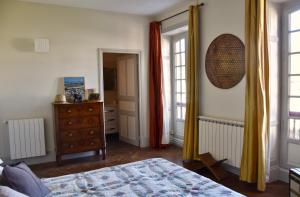 a bedroom with a bed and a dresser and windows at Appartement Erlandebaita Centre bourg 3 personnes in Urrugne