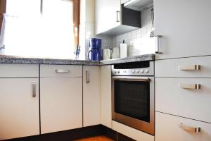 a kitchen with white cabinets and a stove at Ferienhaus Niedernsill in Niedernsill