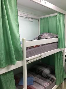 a bunk bed in a room with green curtains at Hostel CUBA in Minsk