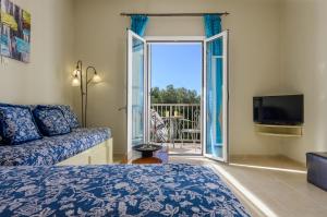a living room with a bed and a sliding glass door at Nikos & Vassilis apartments Kefalonia in Vlachata