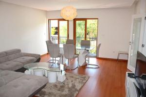 a living room with a couch and a table and chairs at Damaia Apartment in Amadora