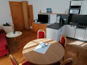 a kitchen and a table in a room with a kitchen and a table and chairs at Appartements-Strandschlößl Heitzmann in Seeboden