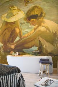 een schilderij van twee vrouwen met hoeden op een muur bij Plein 40 - Lodges in Zoutelande