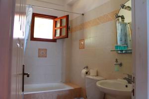 un bagno con vasca, lavandino e WC di Ikaria Utopia - Cusco Studios a Evdilos