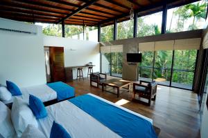 een slaapkamer met 2 bedden en een woonkamer met ramen bij Sakuna Arana Resort in Kosgoda