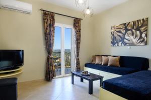 a living room with a couch and a tv at Nikos & Vassilis apartments Kefalonia in Vlachata