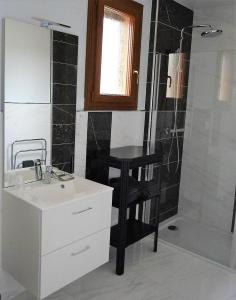 ein Bad mit einem Waschbecken, einer Dusche und einem Tisch in der Unterkunft Le Domaine des Gemmes 