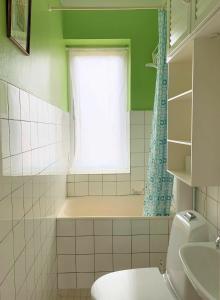 baño con bañera, aseo y ventana en ApartmentInCopenhagen Apartment 700, en Copenhague