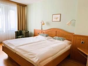 Hotel zur Post في غمبولدسكيرشن: غرفة نوم مع سرير أبيض كبير في غرفة
