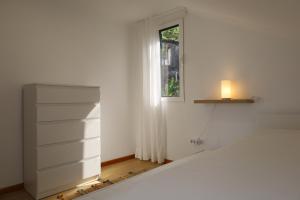 a bedroom with a white bed and a window at Casa das Feiteiras by AnaLodges in Ponta Delgada +54 photos