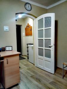 Zimmer mit Tür und Uhr an der Wand in der Unterkunft Király Apartman in Gheorgheni
