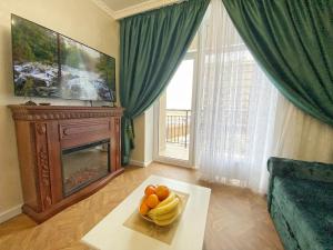 Kikasso Art Apart Odessa في نهر فونتانكا: غرفة معيشة مع طاولة مع وعاء من الفواكه عليها