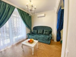 Kikasso Art Apart Odessa في نهر فونتانكا: غرفة معيشة مع أريكة خضراء وطاولة