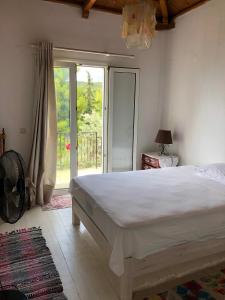 Un dormitorio con una gran cama blanca y una ventana en Villa Myrto - Beautiful see-view villa, en Stafylos